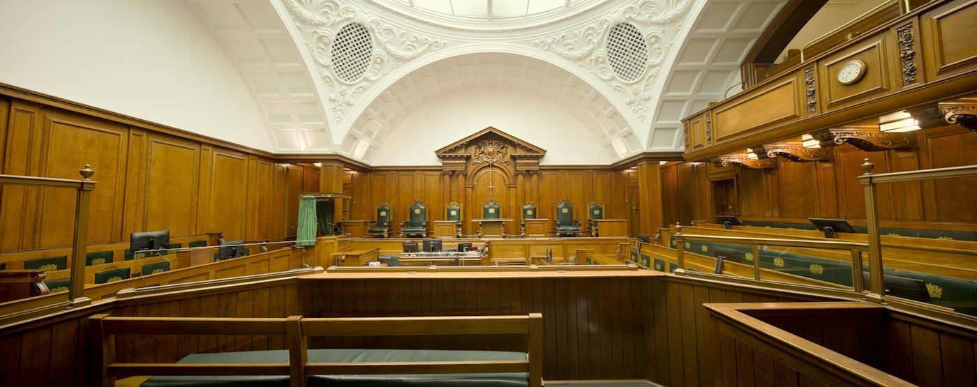 Salle d'audience vide aux boiseries anciennes — droit pénal à Charleroi